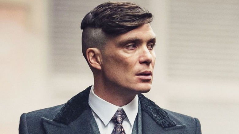 Tommy Shelby looks menacingly to his left in 