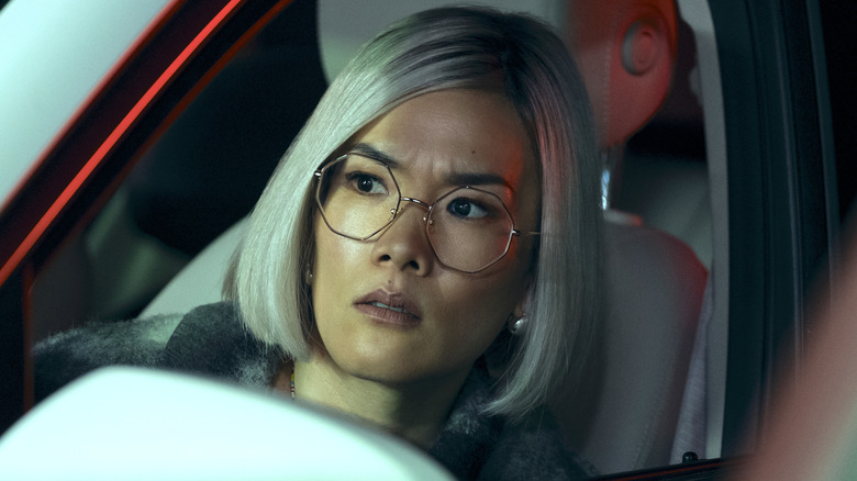 Amy Lau with blonde hair looking out car window