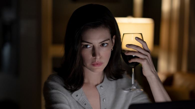 Verity Crawford holding glass of wine at night in Verity (2026)