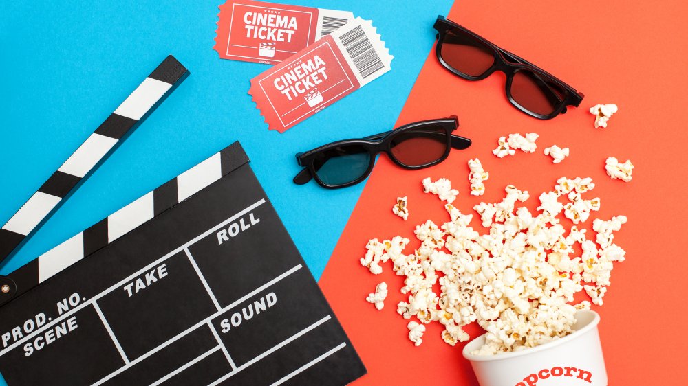 Movie tickets, popcorn, film slate, and 3D cinema glasses