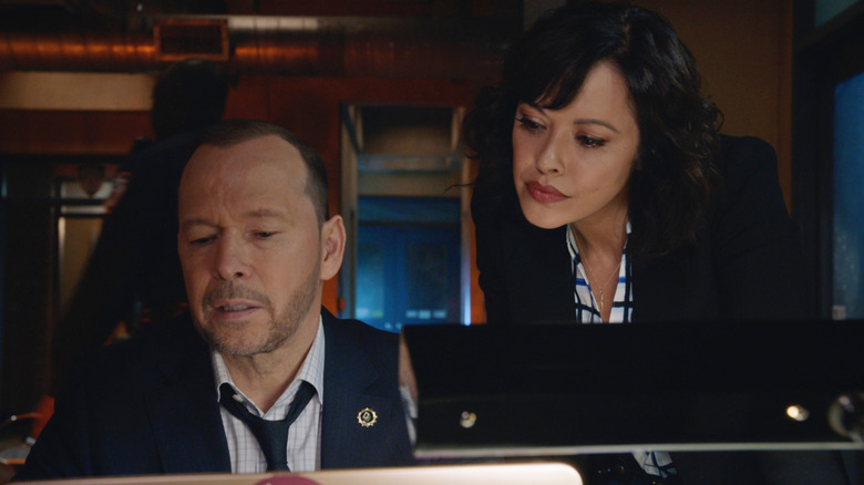 Danny and Maria stare at a computer in 