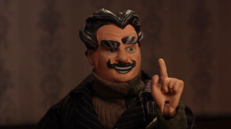 Bond villain holding up his finger and smiling