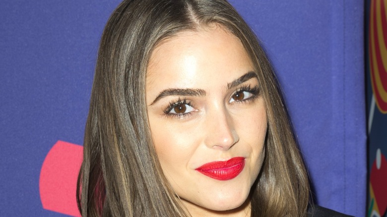 Olivia Culpo smiling with red lipstick at event