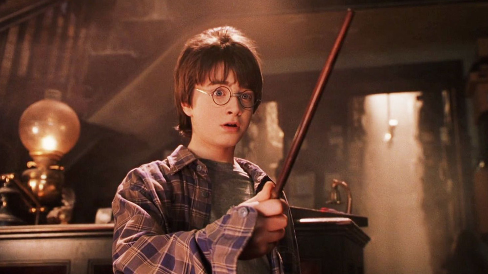 Daniel Radcliffe as Harry Potter holding wand in the wand shop