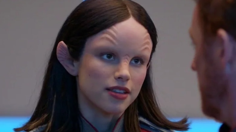 Alara without any eyebrows talking to a crewman