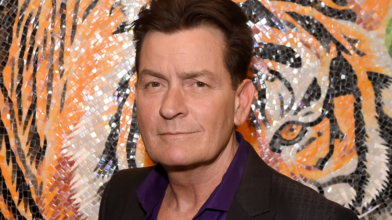 Sheen stands in front of a tiger mosaic