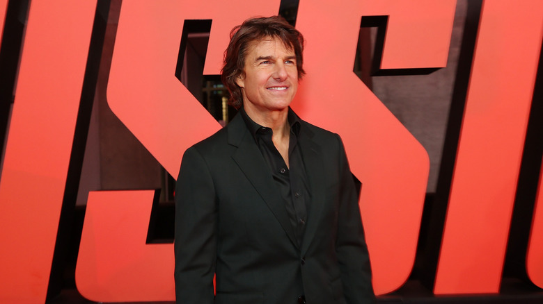 Tom Cruise in front of "Mission: Impossible" sign
