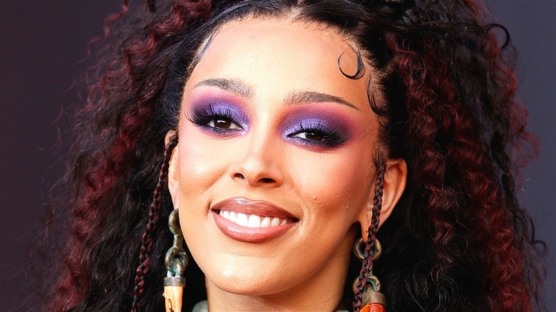 Doja Cat with purple eyeshadow smiling