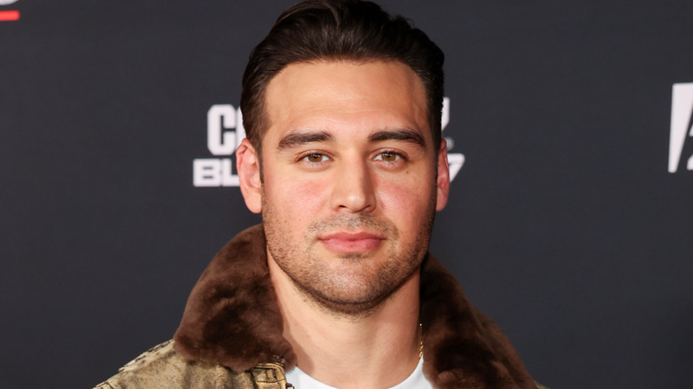 Ryan Guzman wearing fur collared jacket