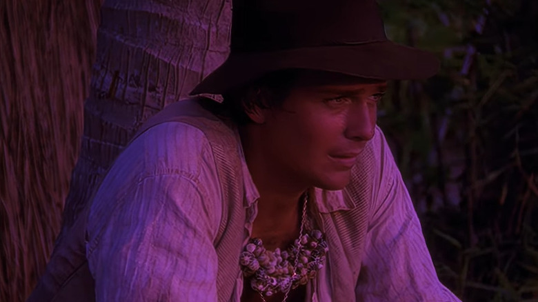 Indiana Jones sitting on a log 