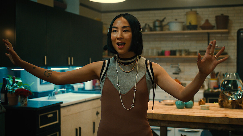 Maxine smoking a cigarette with her arms spread wide on Russian Doll