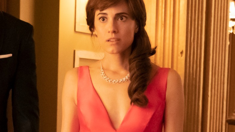 Kit looking surprised wearing a pink dress and diamond necklace