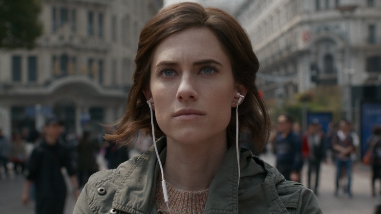 Charlotte wearing earbuds and looking thoughtful