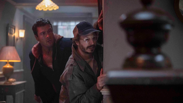 Ben Richards and Elton Parrakis hiding from enemy forces in "The Running Man" (2025)