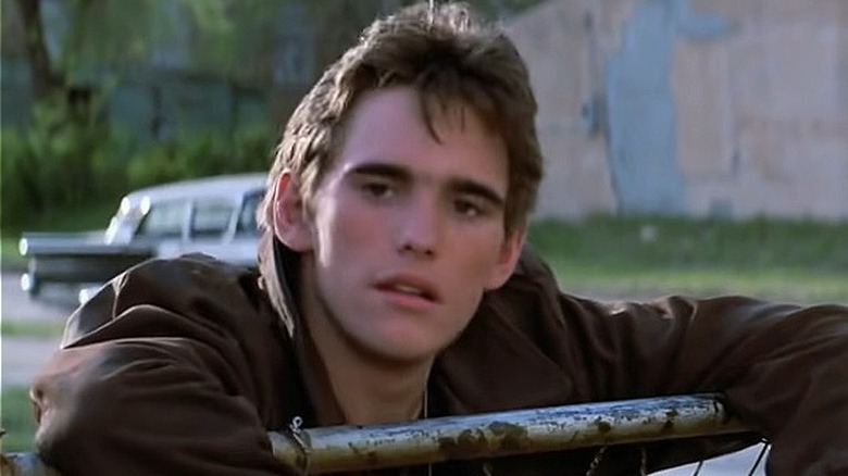 Dallas Winston leaning on fence
