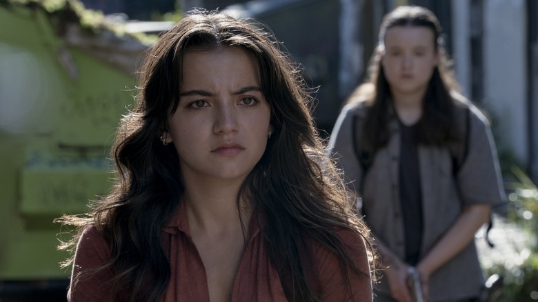 Dina staring straight ahead with Ellie behind her on The Last of Us