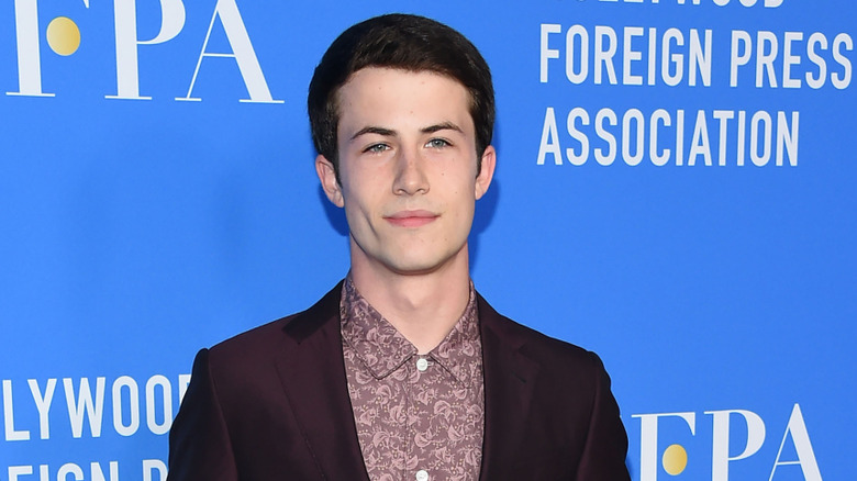 Dylan Minnette wearing a suit against a blue HFPA backdrop