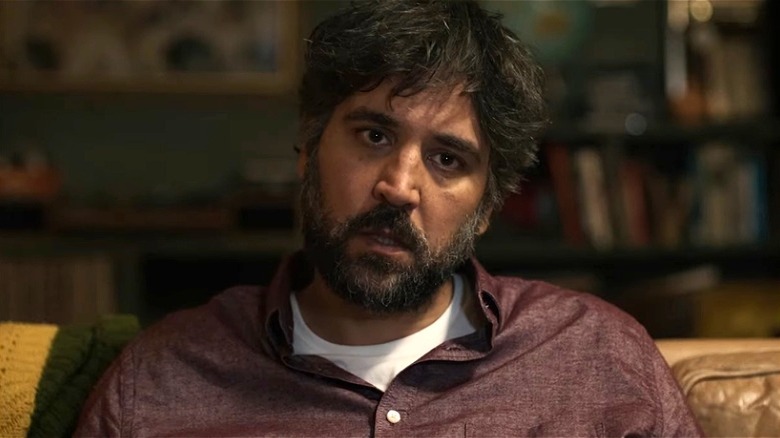 Graham sitting with head cocked in All Happy Families (2023)