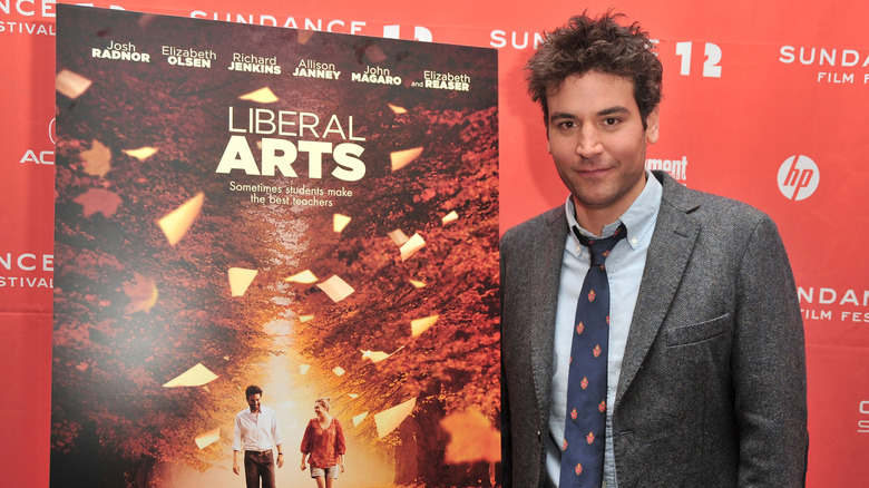 Josh Radnor standing next to a poster for his film Liberal Arts