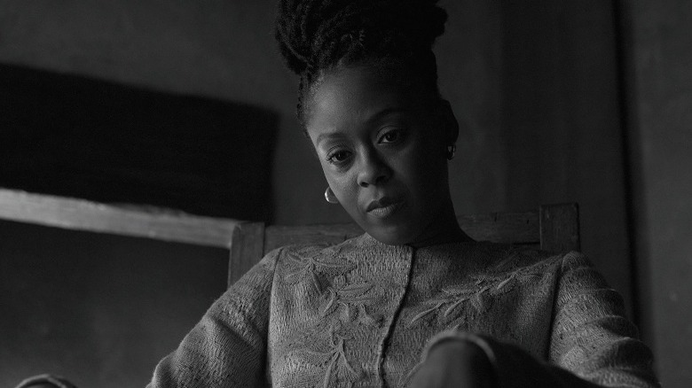 Lady Macduff sits in a chair and looks down