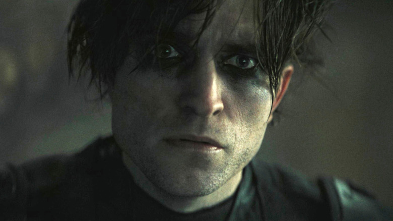 Robert Pattinson's Batman without his mask staring intently in The Batman