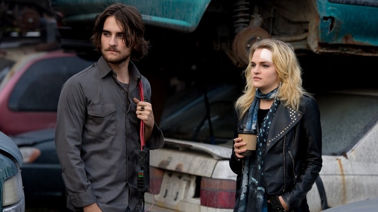 Miranda and Peter standing in junk yard