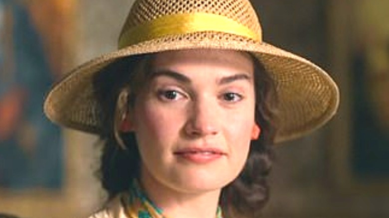 Lily James as Linda Radlett wearing hat