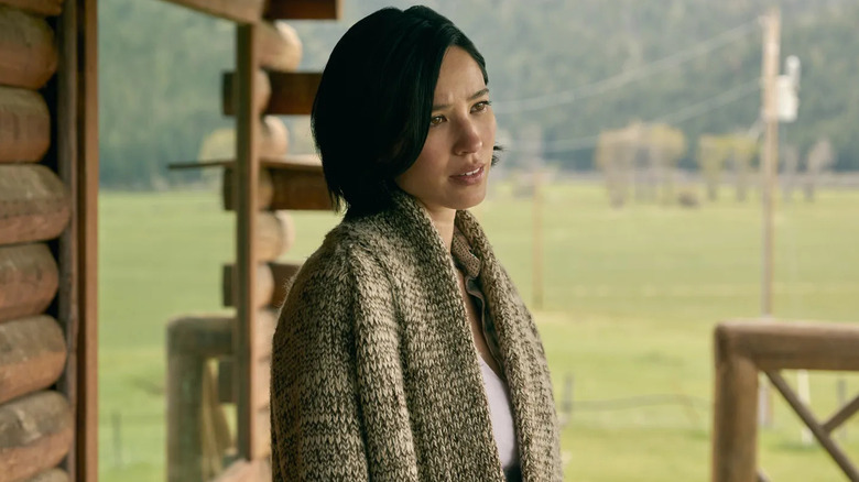 Monica standing on the porch of the cabin in "Yellowstone"