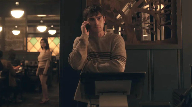Bear on the phone while Nikki lurks around the corner in "Obsession" (2026)