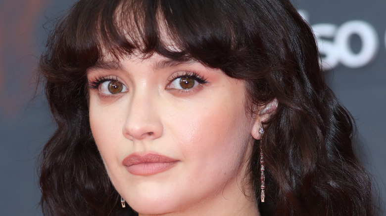 Olivia Cooke on the red carpet looking at the camera 