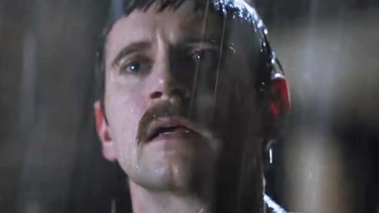 Allen Leech as Paul standing in rain