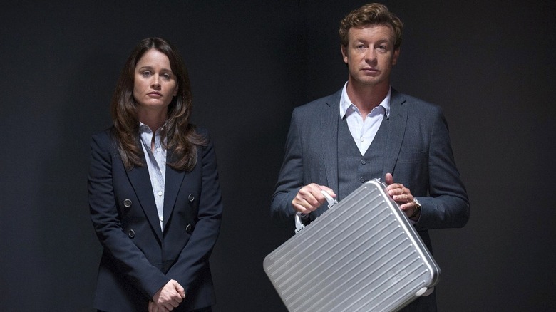 Teresa and Patrick standing in a dark room together  in "The Mentalist"
