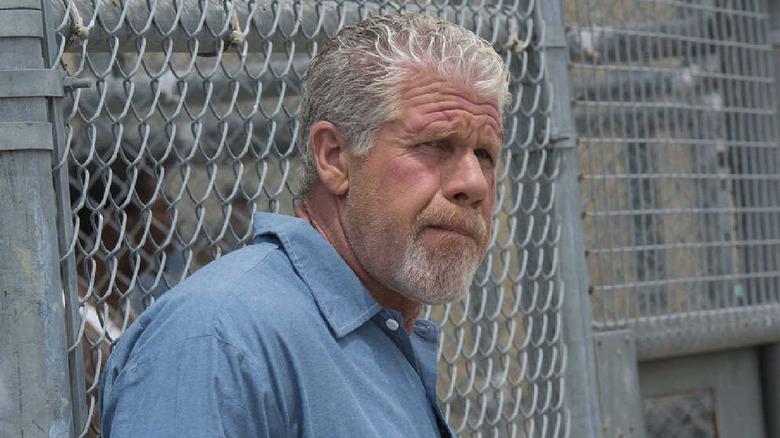 Clay Morrow leaning on fence