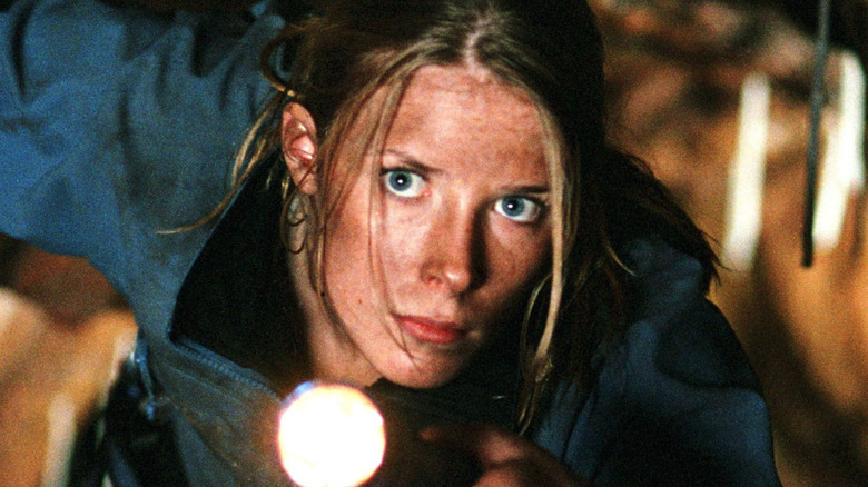 Sarah shines a flashlight ahead in "The Descent" (2005)