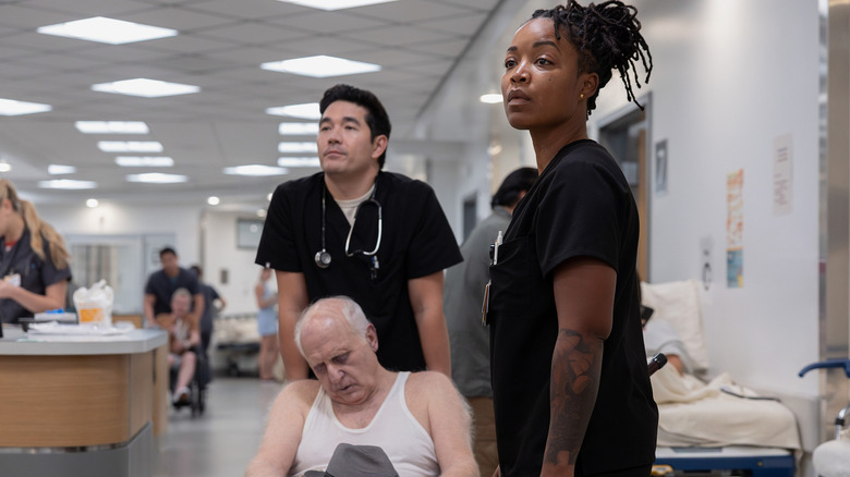 Dr. Shen and Dr. Ellis stand over an elderly patient in a wheelchair on "The Pitt" (2025-present)