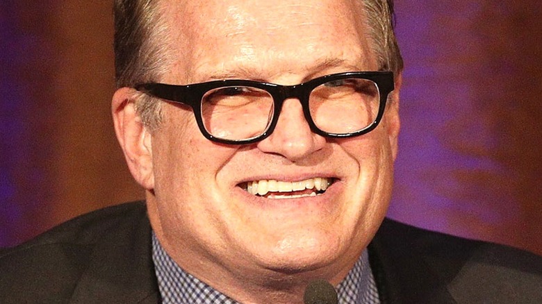 Drew Carey speaking into microphone 