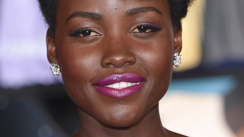 Lupita Nyong'o at event smiling