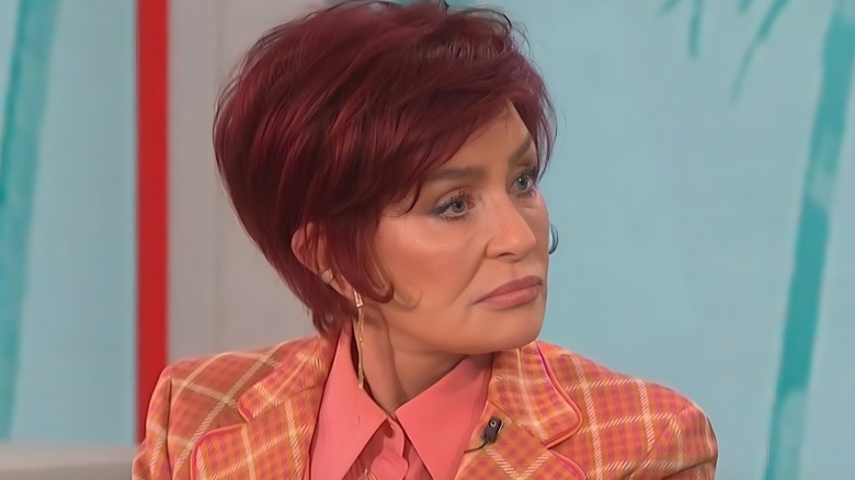 Sharon Osbourne looking serious to the right