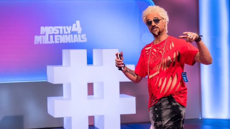 Derrick Beckles in holed shirt hosting Mostly 4 Millennials (2018)