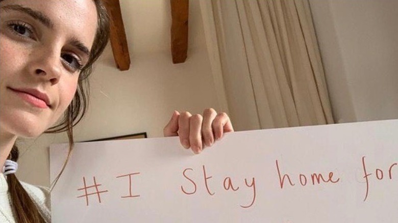 Emma Watson holds up a #IStayHomeFor sign in an Instagram post