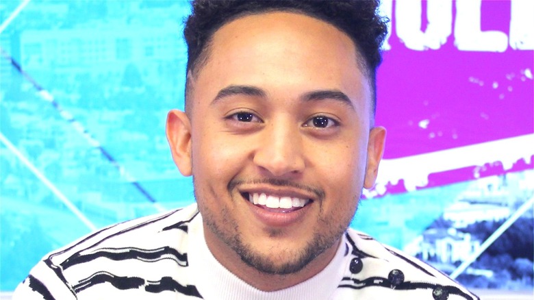 Tahj Mowry smiling for press