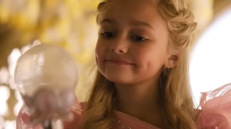 Young Glinda looks into her magic wand in 