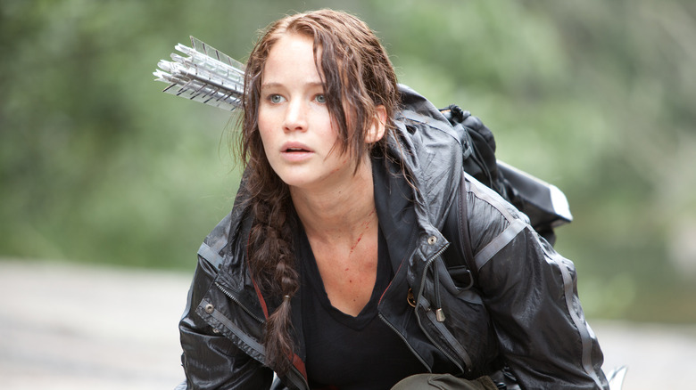 Katniss Everdeen crouching in the woods