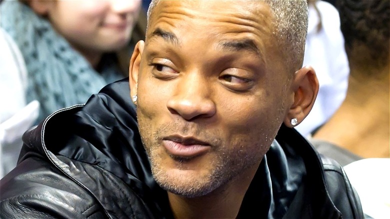 Will Smith smirking at a basketball game