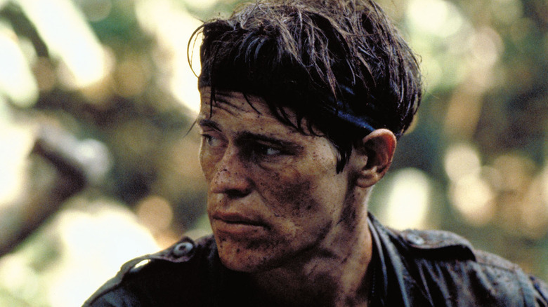 Willem Dafoe looks to his right