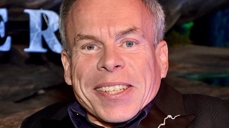 Warwick Davis smiling at premiere