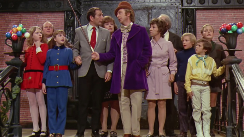 Willy Wonka standing in front of crowd with cane