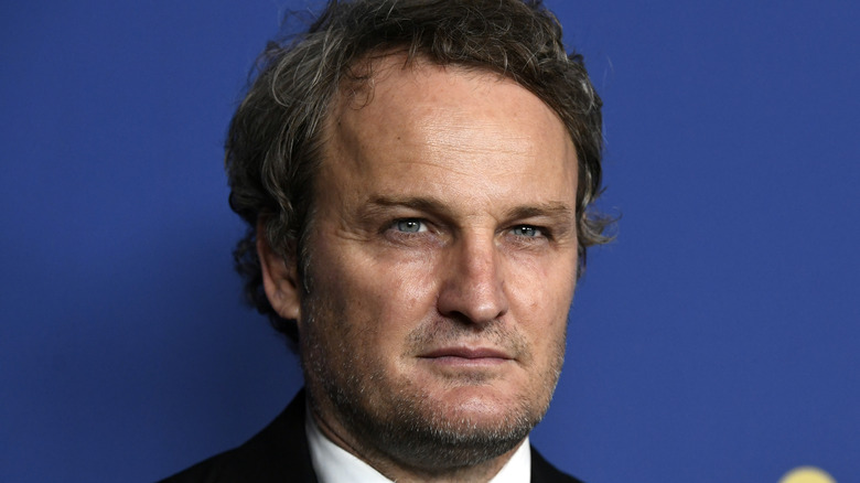 Jason Clarke on blue background