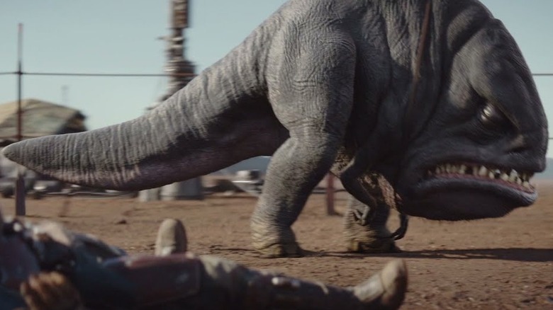 A Blurrg tromps back and forth in its pen while Din Djarin lays on the ground in season 1 of The Mandalorian (2019)