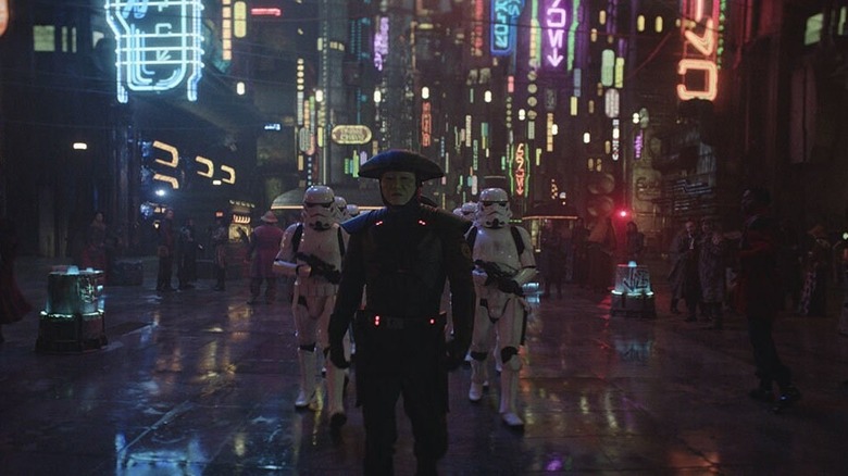 An Imperial Inquisitor with a squad of stormtroopers at night on a neon-lit city street in Obi-Wan Kenobi (2022)